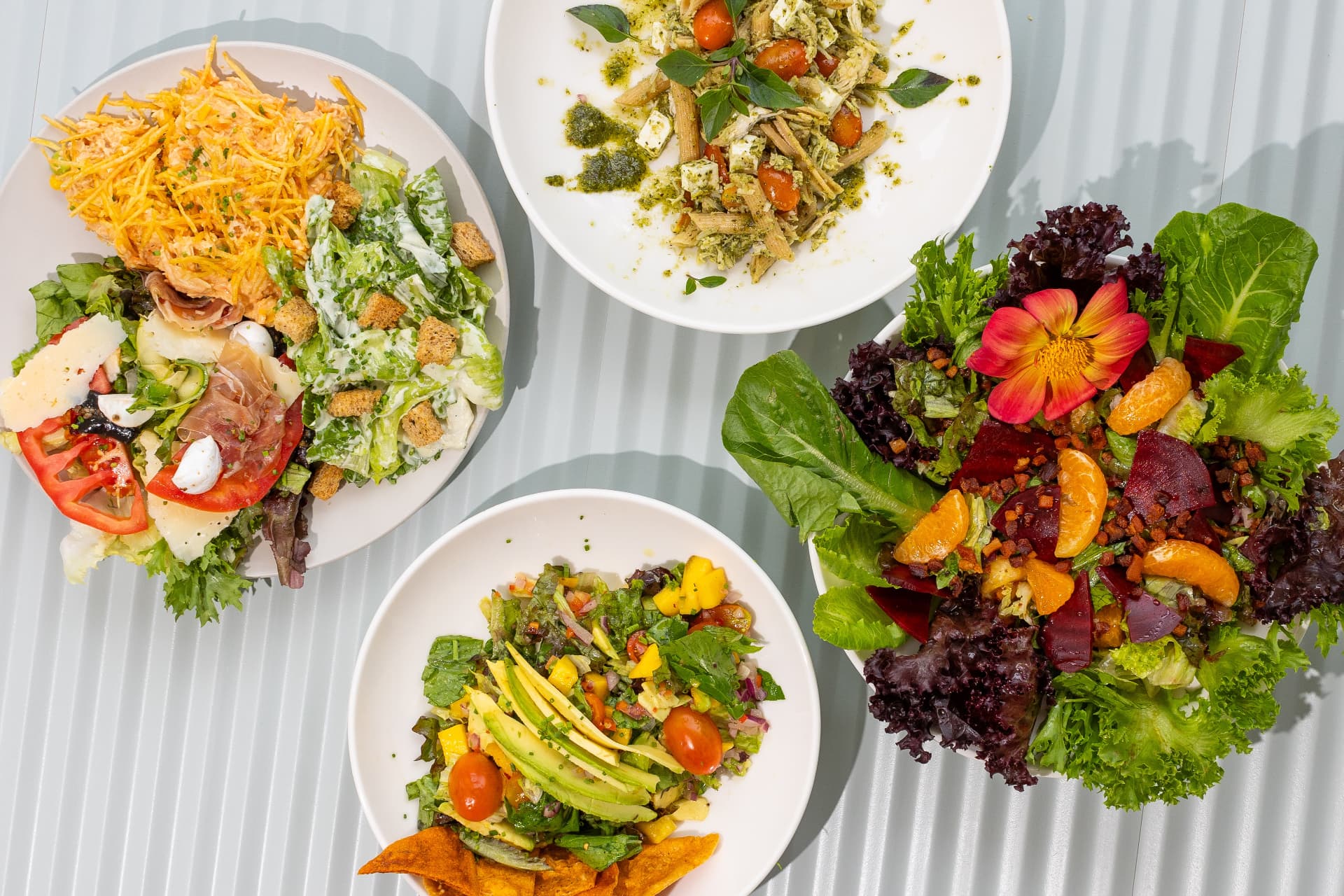 Saladas da Liv Garden vistas de cima: salpicão, caesar, parma e salada de folhas com beterraba